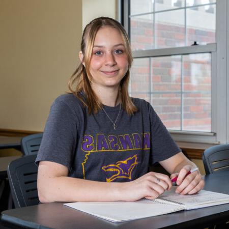 Woman sitting in class with notebook